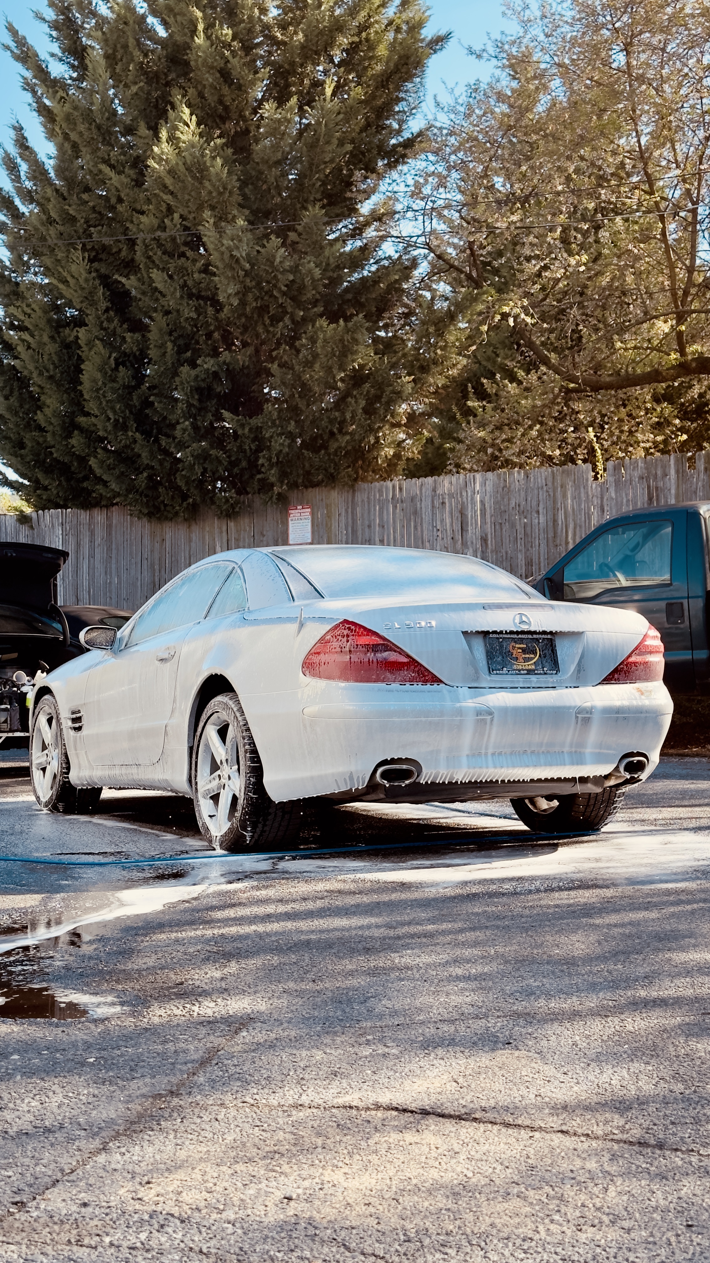 Silver Mercedes-Benz SL under foam, rear three-quarter view