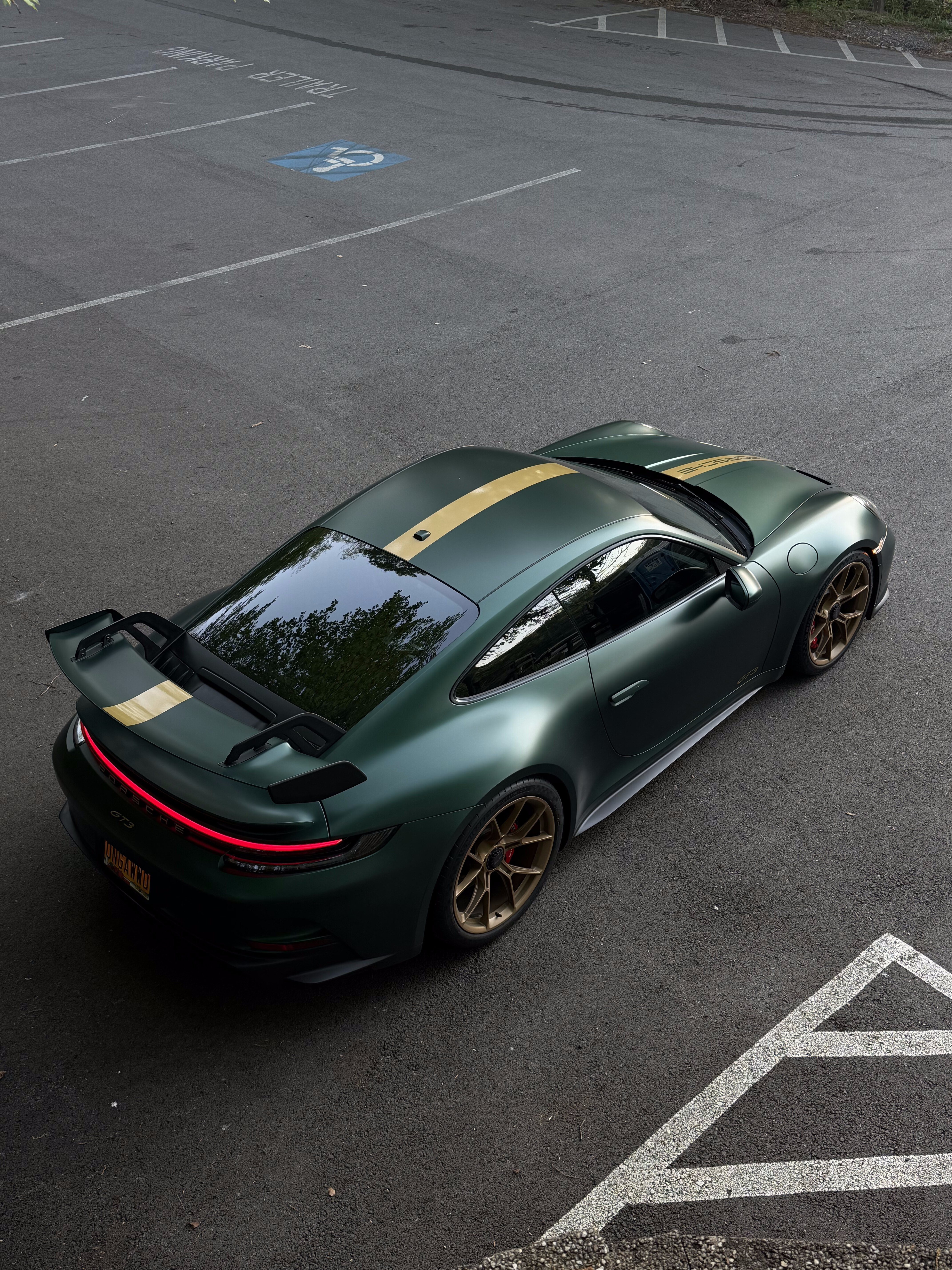 Green Porsche 911 GT3 with gold stripe and bronze wheels, overhead rear view